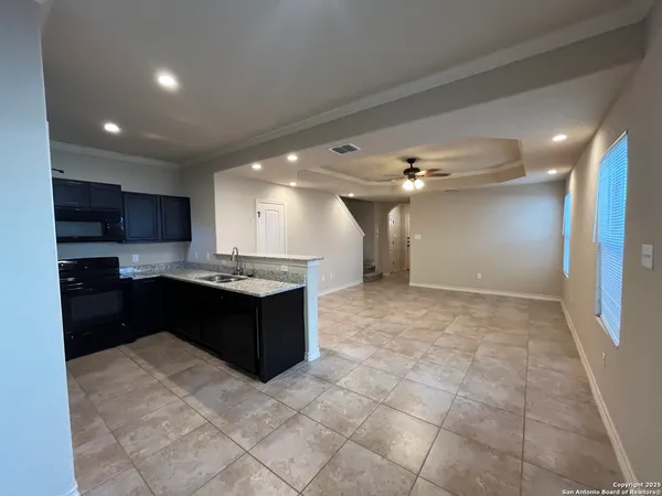 a open kitchen with kitchen island granite countertop a refrigerator and a sink