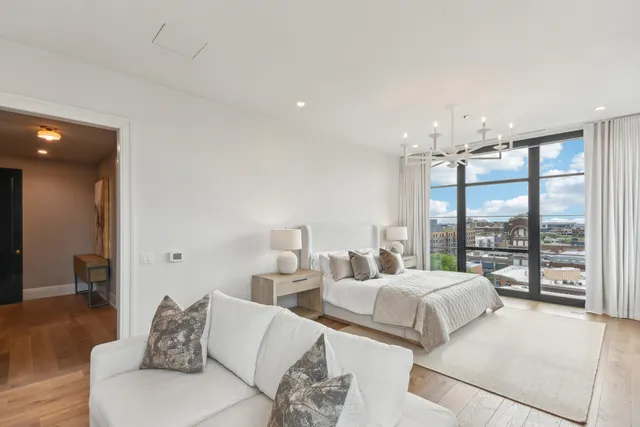 a bedroom with a bed and a large window