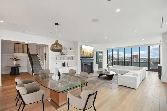 a living room with fireplace furniture and a large window