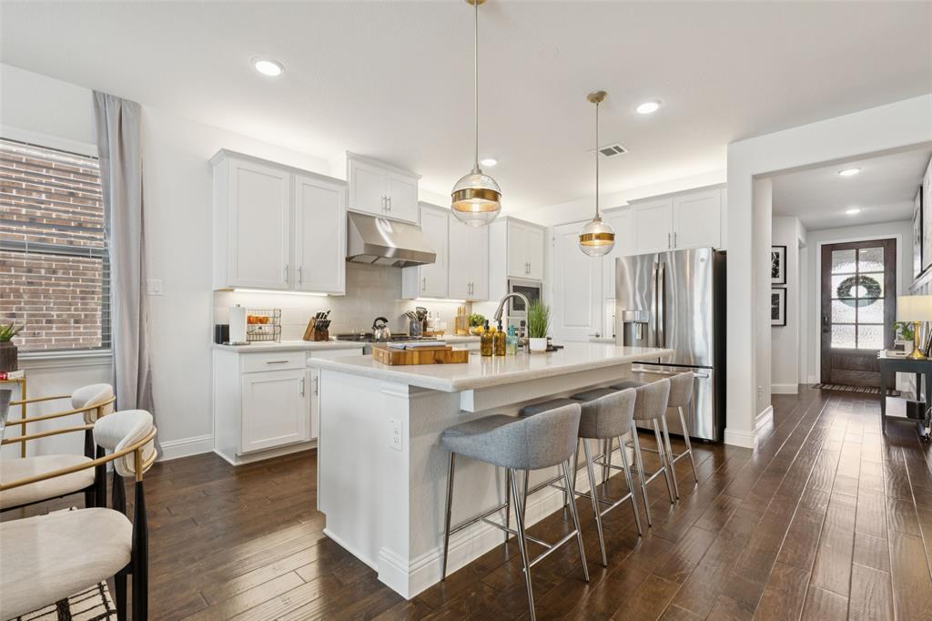 2236 Madison Street Carrollton, TX 75010 - Photo 6 of 37 a kitchen with stainless steel appliances kitchen island granite countertop a table chairs and a refrigerator