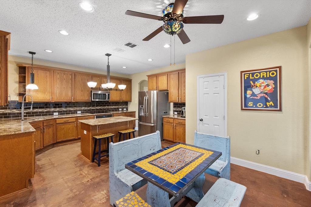 1305 Liverpool Lane Mansfield, TX 76063 - Photo 20 of 40 Spacious kitchen featuring wood cabinetry, granite countertops, a central island, and stainless steel appliances