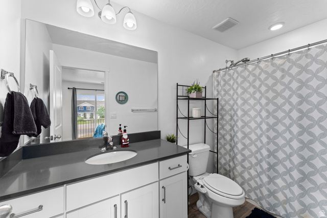 878 North Old Rnch Road Lehi, UT 84048 - Photo 15 of 36 Contemporary bathroom featuring a single vanity with a dark countertop, white cabinetry with silver hardware, a built-in shower, and recessed lighting
