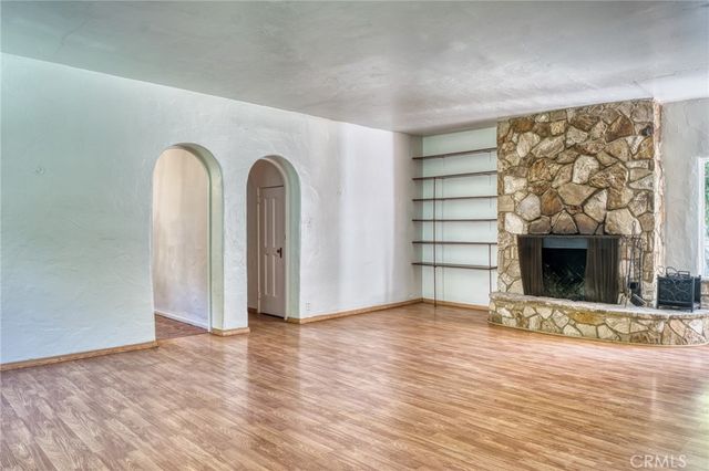 a view of an empty room with a fireplace and a window