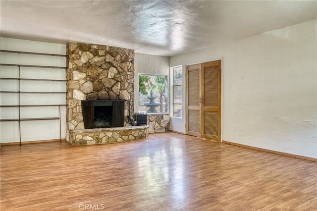 a view of an empty room with a fireplace and a window