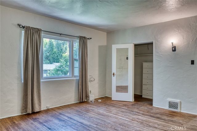 a view of an empty room with closet and a window