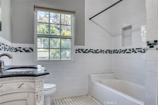 a bathroom with a sink a bathtub and a window