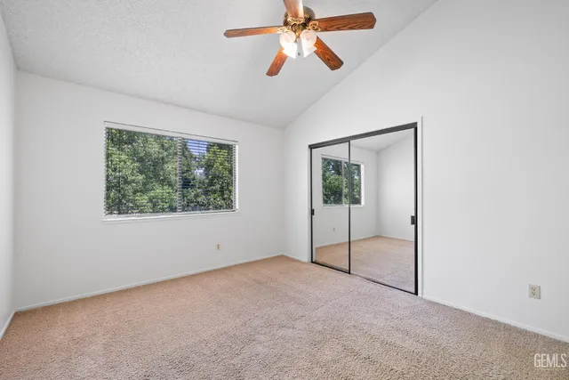 a view of a room with a ceiling fan and window