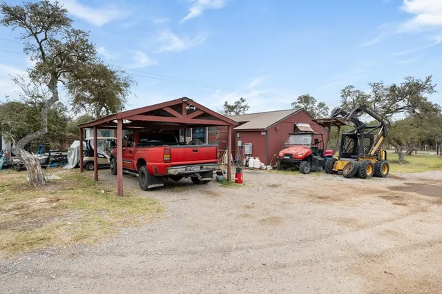 a backyard of a house with barbeque oven a table and chairs