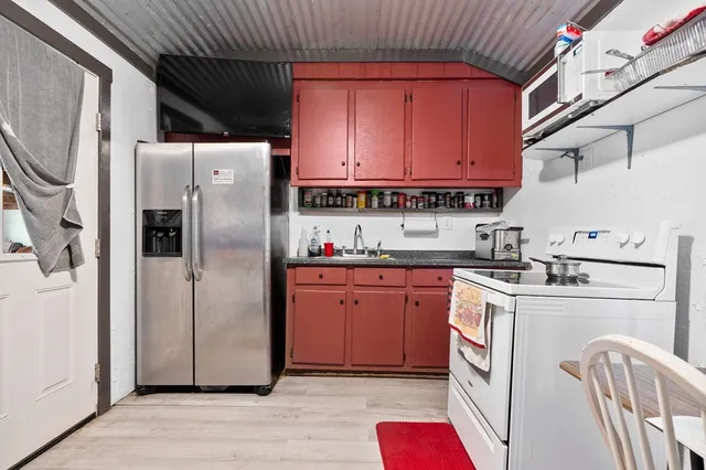 a kitchen with stainless steel appliances granite countertop a refrigerator a sink dishwasher a stove with wooden cabinets