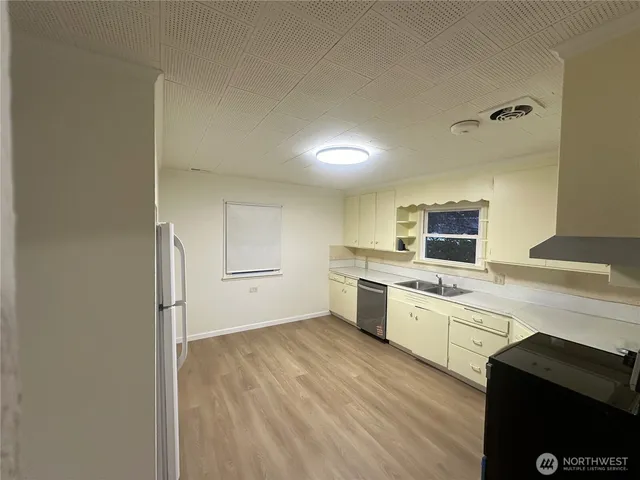 a kitchen with stainless steel appliances a sink a stove a refrigerator and cabinets