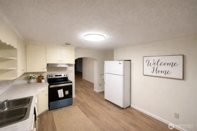 a kitchen with refrigerator cabinets and wooden floor