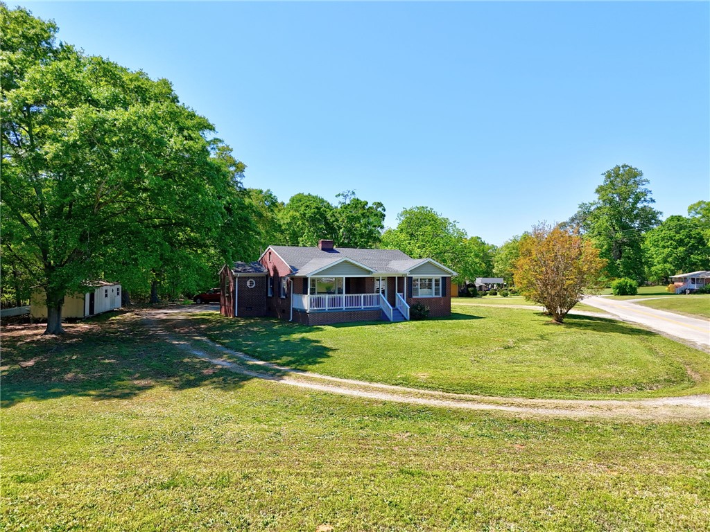 301 Clinkscales Street Iva, SC 29655 - Photo 24 of 36 This charming home features a lovely front porch and a spacious yard, surrounded by lush greenery.