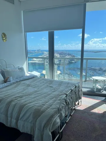 a bed sitting in a bedroom next to a large window