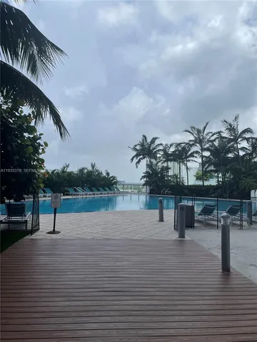a view of a white house with a yard and a fountain
