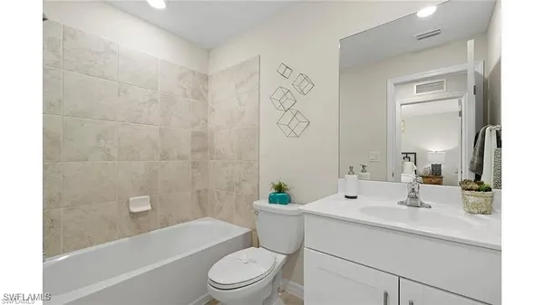 a bathroom with a sink a toilet a mirror a bathtub and shower