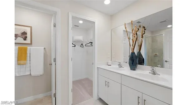 a bathroom with a double vanity sink mirror and shower