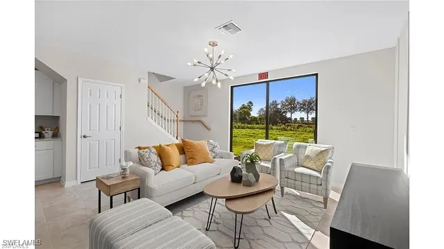 a living room with furniture a chandelier and a window