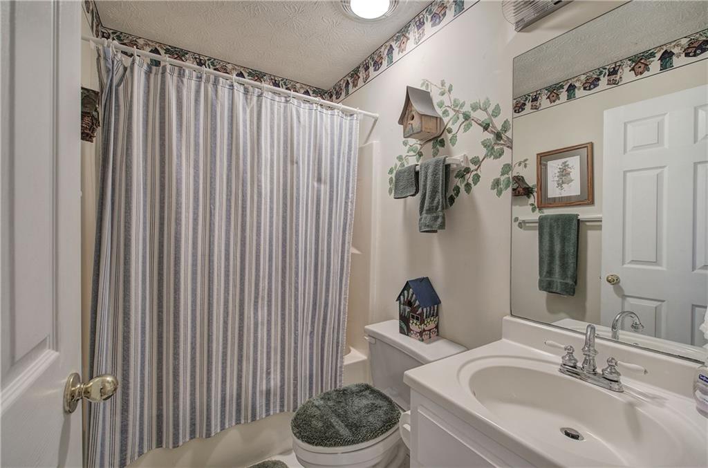 1379 Little Hendricks Mountain Road Jasper, GA 30143 - Photo 29 of 56 a bathroom with a sink a toilet and shower curtain