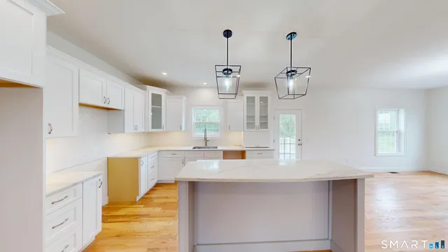 a large kitchen with granite countertop a white stove top oven a dining table and chairs