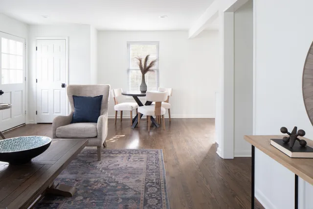a dining room with furniture wooden floor a rug and a painting