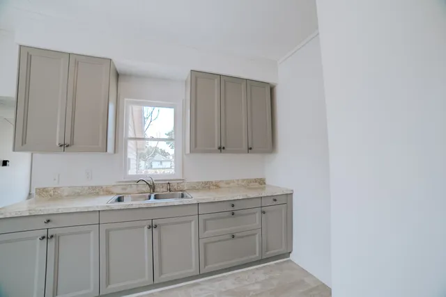 a bathroom with a granite countertop sink and a mirror