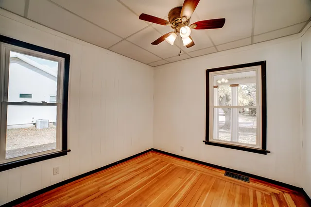 a view of an empty room with a window and a ceiling fan