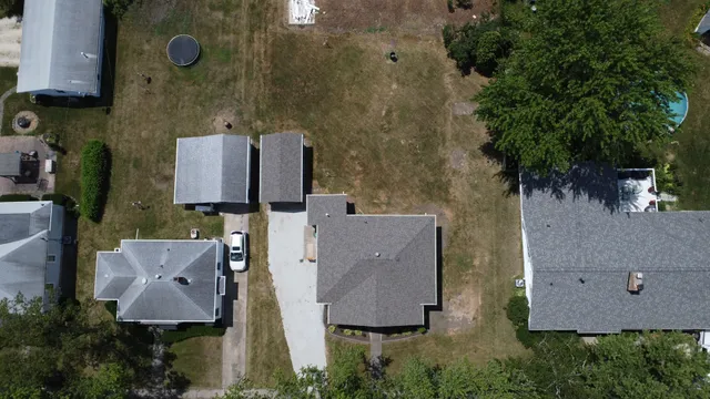 an aerial view of residential houses with outdoor space and parking