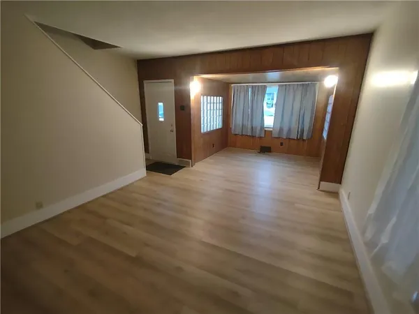 a view of a hallway with wooden floor and windows