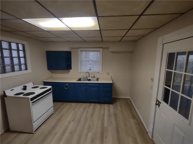 a room with furniture a flat screen tv and kitchen view