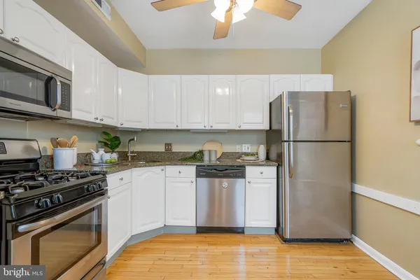 a kitchen with stainless steel appliances granite countertop a refrigerator stove and sink