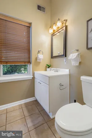 a bathroom with a toilet a sink and a mirror