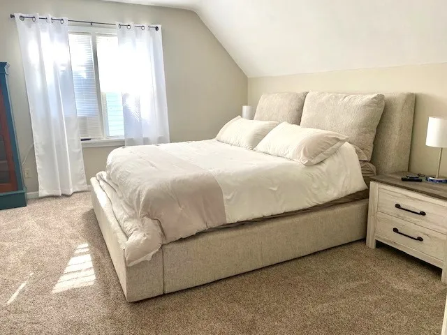 a bedroom with a bed and a large window