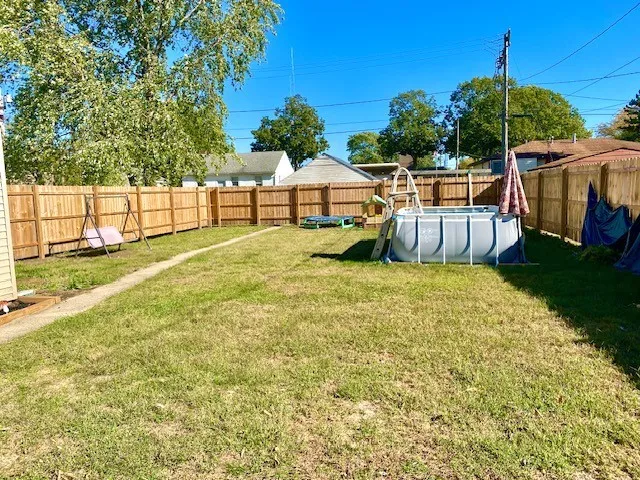 a view of a house with a yard patio and tree