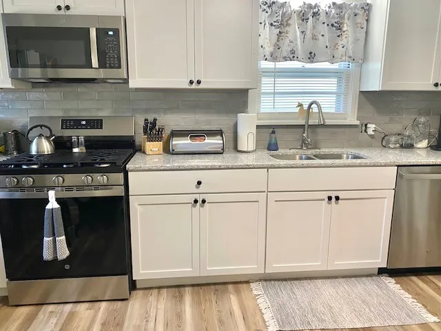 a view of a kitchen with a sink and cabinets