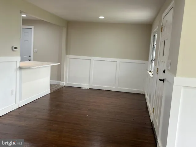 a view of a hallway with wooden floor and closet