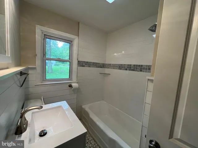 a bathroom with a tub a sink and a window