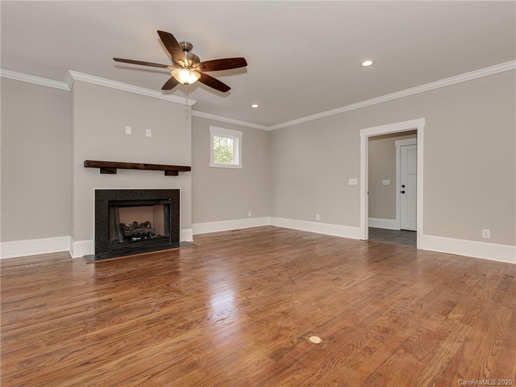 1808 Berryhill Road Charlotte, NC 28208 - Photo 14 of 34 a view of an empty room with wooden floor a fireplace and a window