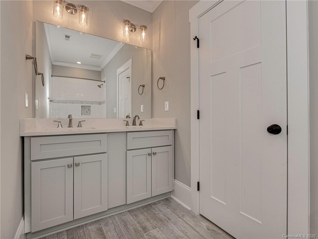 1808 Berryhill Road Charlotte, NC 28208 - Photo 20 of 34 a bathroom with a double vanity sink a mirror a shower and vanity