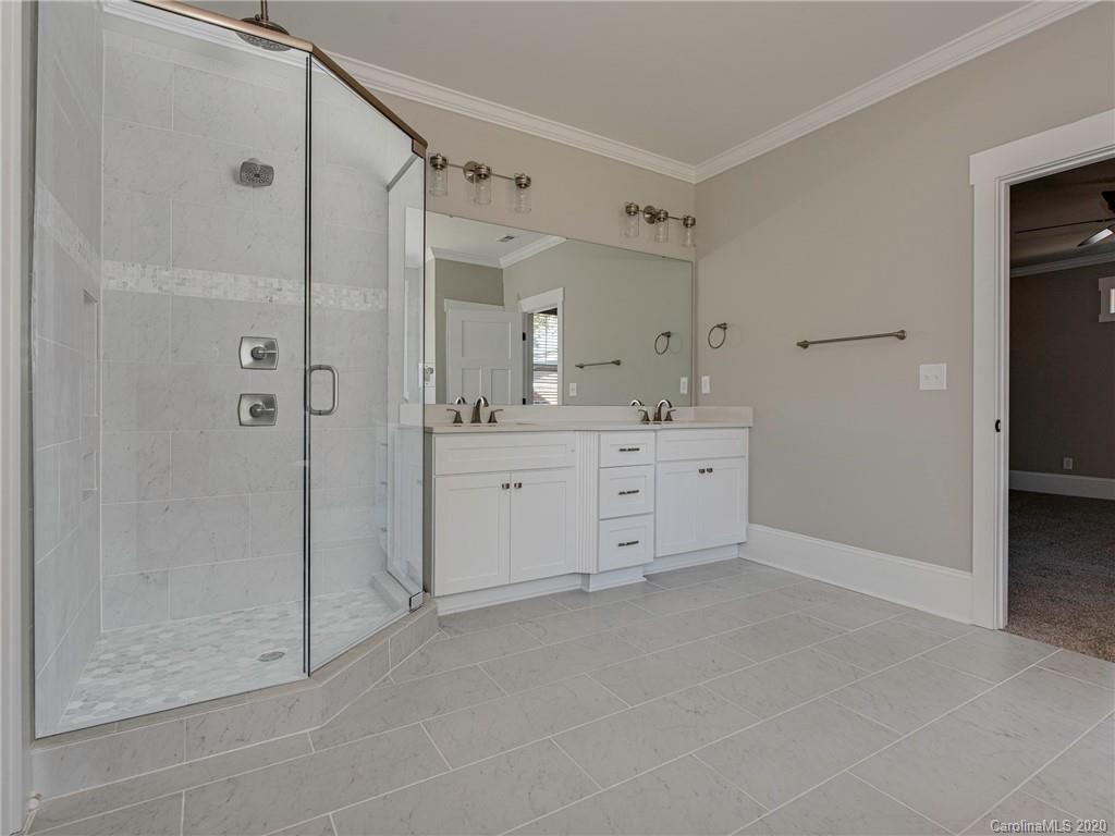 1808 Berryhill Road Charlotte, NC 28208 - Photo 26 of 34 a spacious bathroom with a shower sink and mirror