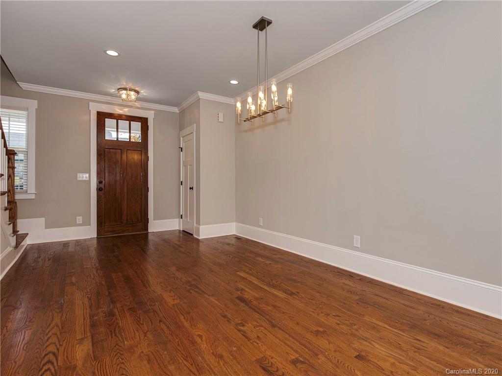 1808 Berryhill Road Charlotte, NC 28208 - Photo 4 of 34 a view of an empty room with wooden floor and a chandelier