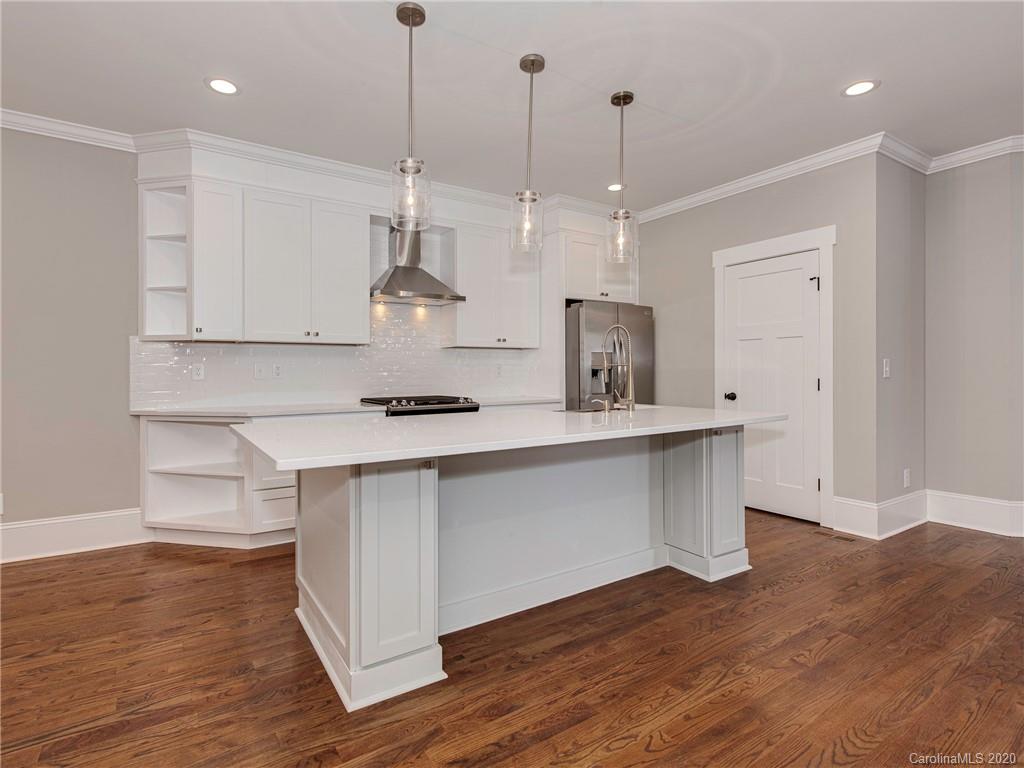 1808 Berryhill Road Charlotte, NC 28208 - Photo 6 of 34 a kitchen with stainless steel appliances granite countertop a sink a stove a refrigerator and white cabinets with wooden floor