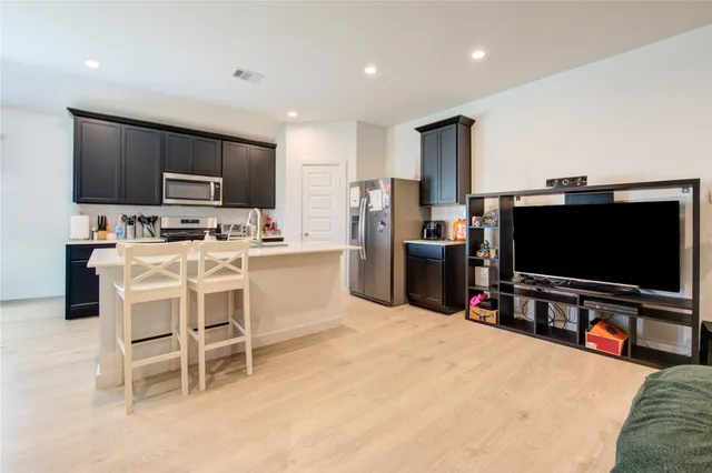a kitchen with kitchen island a sink stainless steel appliances and cabinets