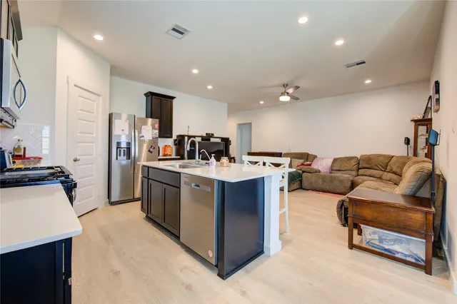 a kitchen with stainless steel appliances a stove refrigerator sink and microwave