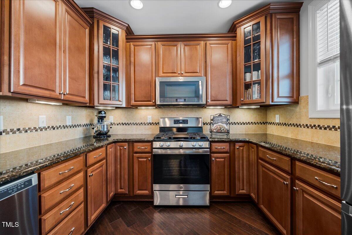 10520 Sablewood Drive, Unit 103 Raleigh, NC 27617 - Photo 12 of 38 a kitchen with stainless steel appliances granite countertop a stove a sink and a microwave