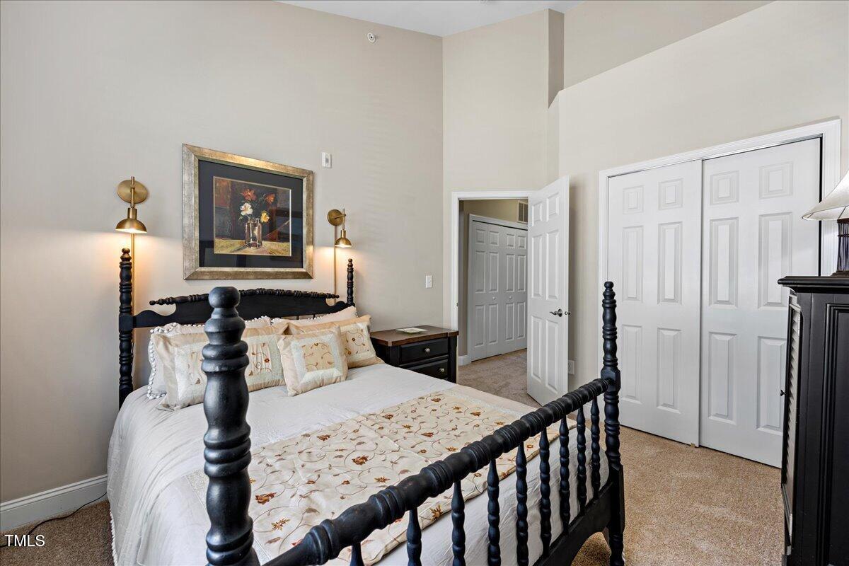 10520 Sablewood Drive, Unit 103 Raleigh, NC 27617 - Photo 22 of 38 a bedroom with a bed and a chandelier