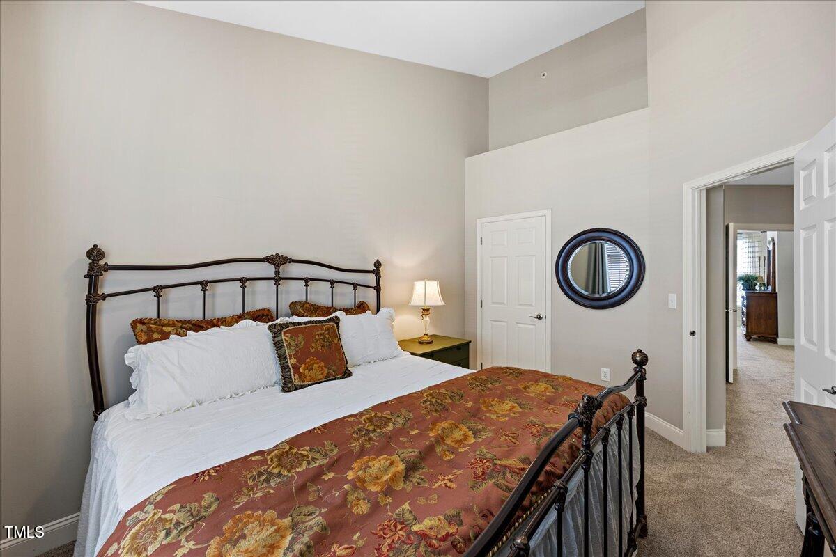10520 Sablewood Drive, Unit 103 Raleigh, NC 27617 - Photo 24 of 38 a bedroom with bed and a mirror