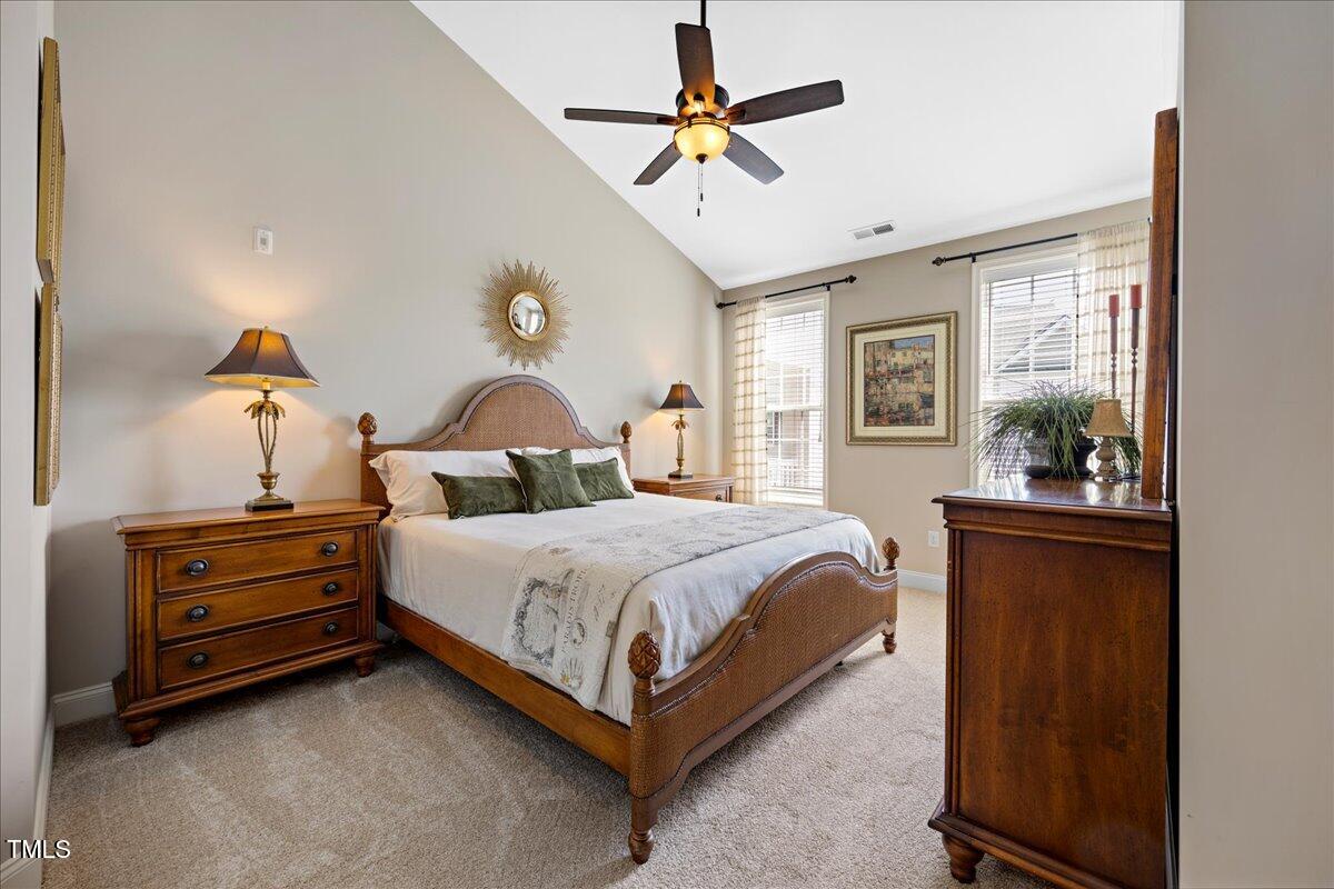 10520 Sablewood Drive, Unit 103 Raleigh, NC 27617 - Photo 25 of 38 a bedroom with a bed and a chandelier