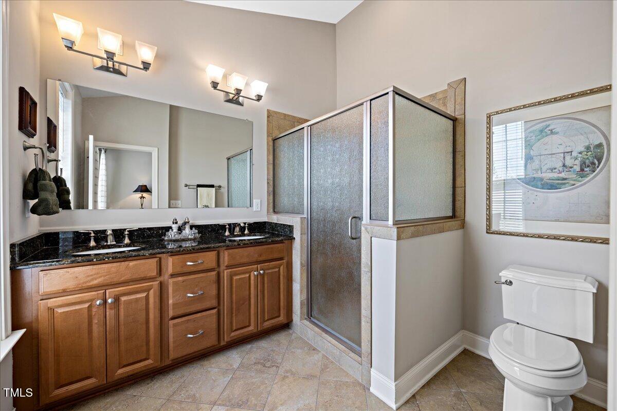 10520 Sablewood Drive, Unit 103 Raleigh, NC 27617 - Photo 28 of 38 a bathroom with a toilet a sink a mirror a vanity and shower