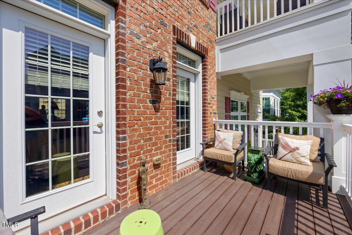 10520 Sablewood Drive, Unit 103 Raleigh, NC 27617 - Photo 31 of 38 a view of a deck with couches chairs with wooden floor and fence