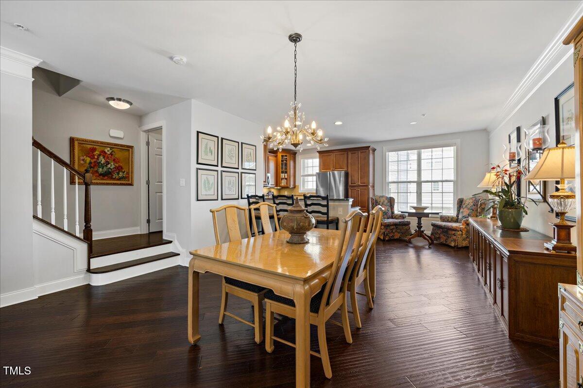 10520 Sablewood Drive, Unit 103 Raleigh, NC 27617 - Photo 7 of 38 a dining room with furniture a chandelier and wooden floor